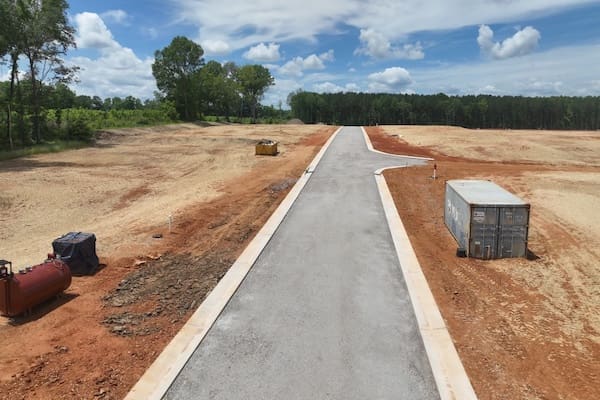Nueva carretera con bordillo y base de piedra, lista para el asfaltado