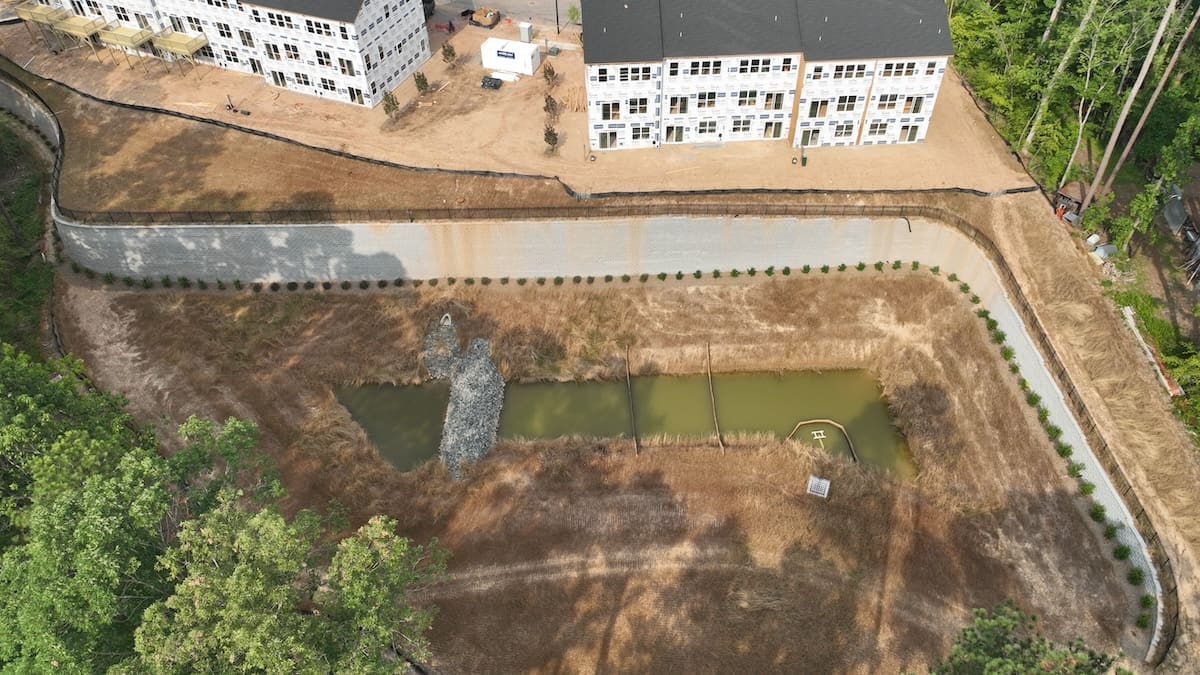 Vista aérea del muro de contención y el estanque en un proyecto de Marks