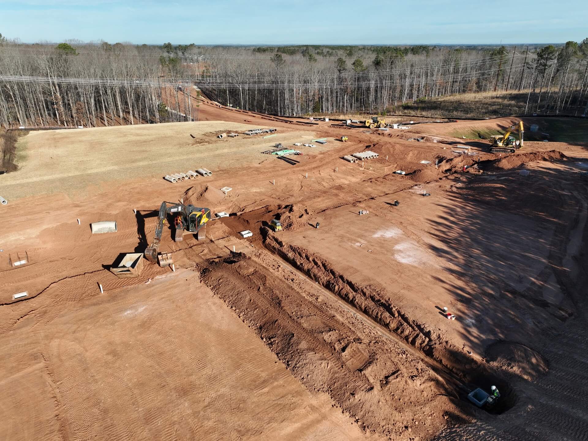 Aerial view of a large Marks Clearing and Grading site with utility trenches open across the pad