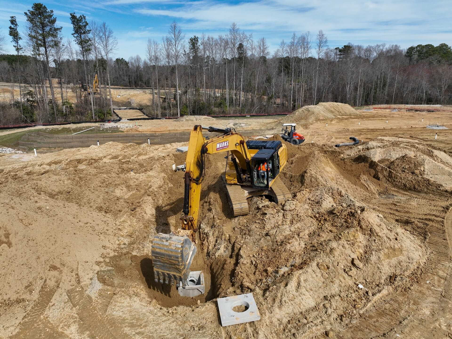 Marks excavator backfilling a completed utility run